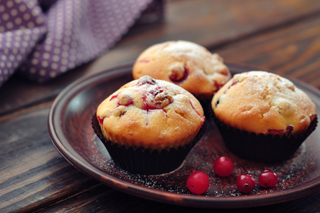 Muffins with cranberry on plate closeup on wooden background  Small shallow DOFの写真素材