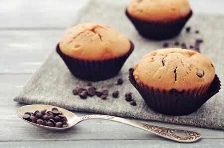 Muffins with chocolate drops on napkin closeup on wooden background の写真素材