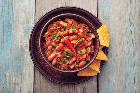 Chili Con Carne in bowl with tortilla chips on wooden backgroundの写真素材