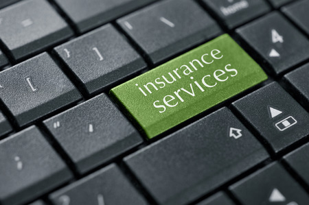 Concept of online insurance. Words insurance services on button of computer keyboard.の写真素材