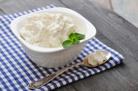 Ricotta cheese in bowl with mint on wooden backgroundの写真素材