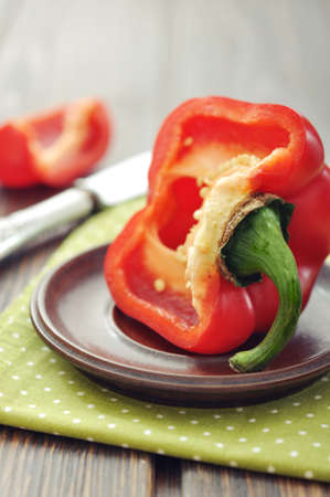 Sweet pepper on plate with knife on wooden backgroundの写真素材
