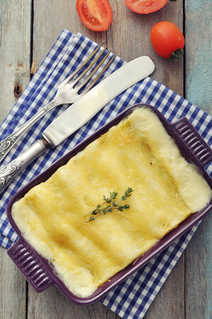 Cannelloni with ricotta and spinach in a baking dish on wooden backgroundの写真素材