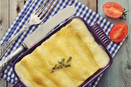 Cannelloni with ricotta and spinach in a baking dish on wooden backgroundの写真素材