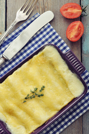 Cannelloni with ricotta and spinach in a baking dish on wooden backgroundの写真素材