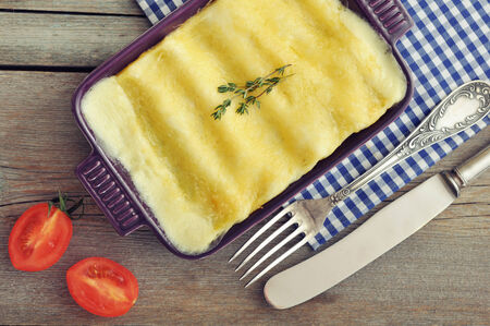 Cannelloni with ricotta and spinach in a baking dish on wooden backgroundの写真素材