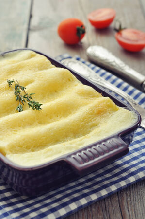 Cannelloni with ricotta and spinach in a baking dish on wooden backgroundの写真素材