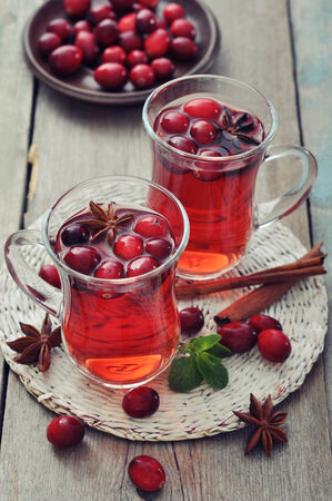 Mulled wine with fresh cranberry and cinnamon on wooden backgroundの写真素材