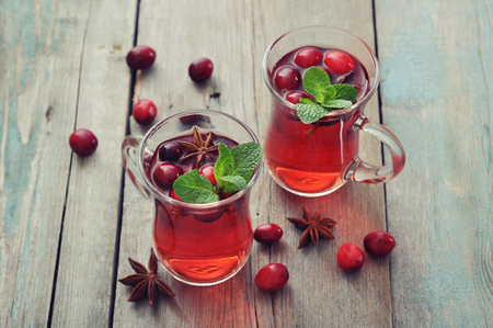 Mulled wine with fresh cranberry and cinnamon on wooden backgroundの写真素材