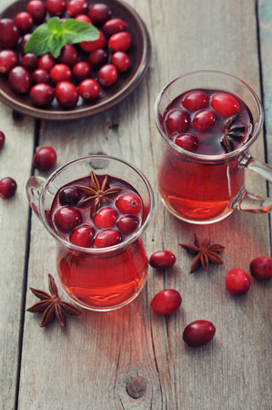 Mulled wine with fresh cranberry and cinnamon on wooden backgroundの写真素材