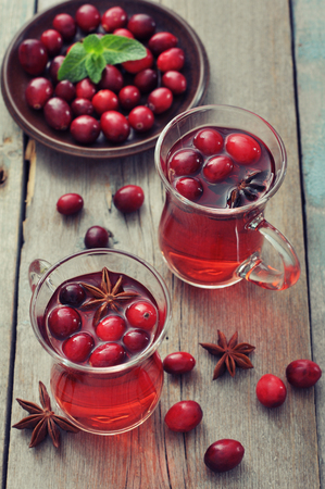 Mulled wine with fresh cranberry and cinnamon on wooden backgroundの写真素材