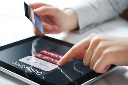 Female hands using touch screen device for online paymentの写真素材