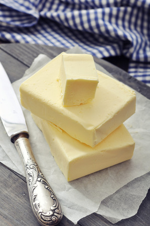 Fresh butter on wooden cutting board with knife closeupの写真素材