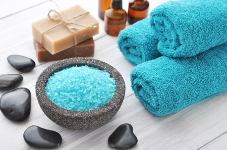Spa composition with blue sea salt and massaging stones on white wooden の写真素材