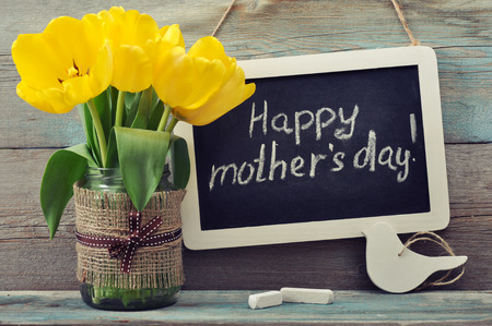 Beautiful tulips bouquet with blackboard and chalk on wooden の写真素材