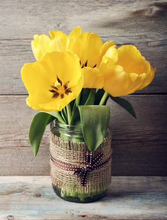 Beautiful tulips bouquet in vase on wooden の写真素材