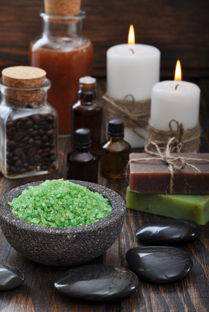 Spa composition with green sea salt and massaging stones on wooden backgroundの写真素材