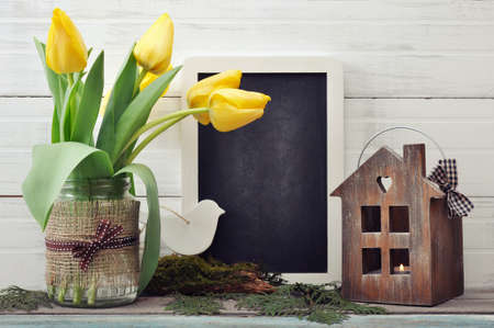 Beautiful tulips bouquet with blackboard and lantern on wooden backgroundの写真素材