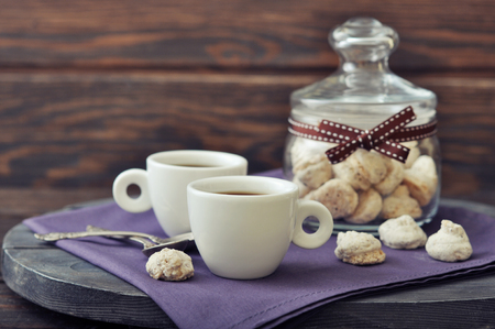 Cup of coffee with fresh biscotti in a glass jar on wooden backgroundの写真素材