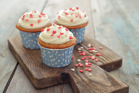 Cupcakes with icing in shape of hearts on wooden backgroundの写真素材