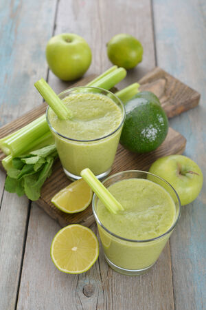 Smoothie of green apple, celery, avocado and lime on wooden backgroundの写真素材