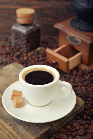 Cup of hot espresso with  vintage coffee grinder on wooden backgroundの写真素材