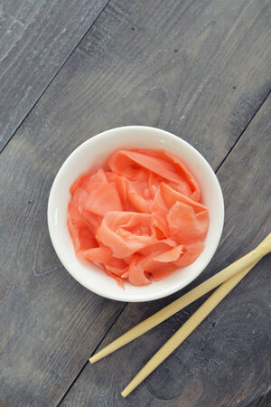 Pickled ginger on plate with wooden chopsticks の写真素材