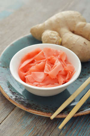 Pickled ginger with wooden chopsticks on plateの写真素材