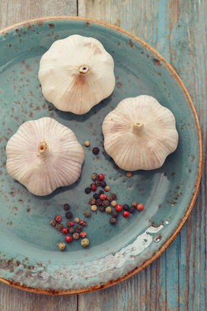 Garlic with pepper on blue plate, top viewの写真素材