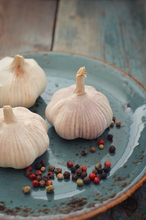Garlic with pepper on blue plate closeupの写真素材