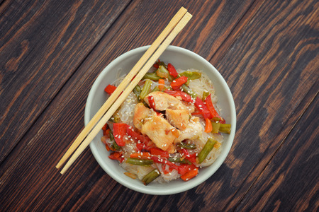 Rice noodles with chicken and vegetables in bowl top viewの写真素材