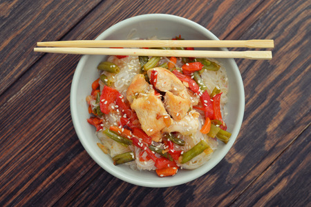 Rice noodles with chicken and vegetables in bowl top viewの写真素材