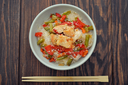 Rice noodles with chicken and vegetables in bowl, top viewの写真素材