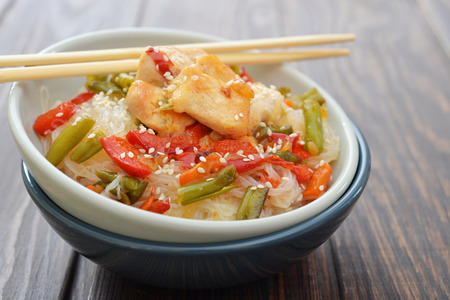Rice noodles with chicken and vegetables in bowl closeupの写真素材
