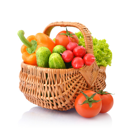 Organic vegetables in the wicker basket isolated on white backgroundの写真素材