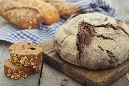 Rye round bread  on cutting board with knife on wooden background
の写真素材