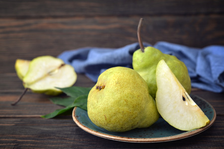 Fresh pears on plate over wooden background closeupの写真素材