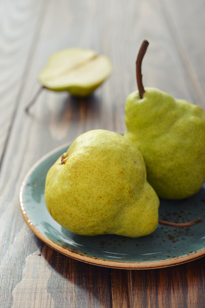 Fresh pears on plate over wooden background closeupの写真素材