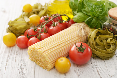 Spaghetti with fresh ripe tomato and basil on wooden background closeupの写真素材