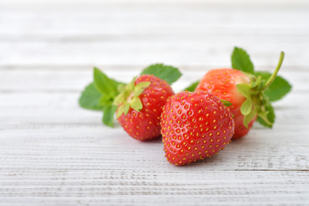 Fresh ripe strawberry closeup on wooden backgroundの写真素材