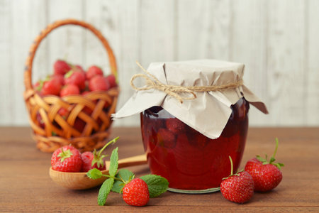 Strawberry jam in a jar with fresh berries on  the wooden backgroundの写真素材