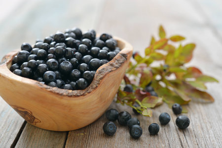 Fresh blueberry in wooden bowl on wooden backgroundの写真素材