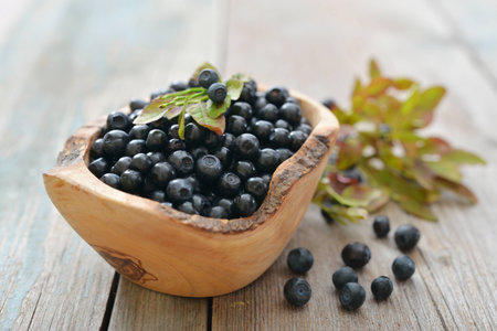 Fresh blueberry in wooden bowl on wooden backgroundの写真素材
