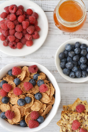 Whole-grain flakes in bowl with fresh berries on light backgroundの写真素材