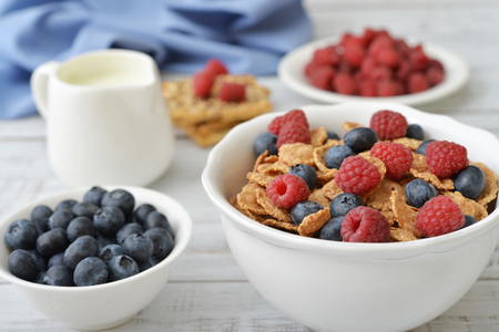 Whole-grain flakes in bowl with fresh berries on light backgroundの写真素材