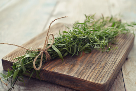 Fresh tarragon on wooden cutting board closeupの写真素材