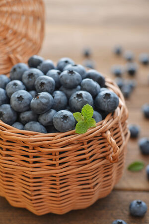 Fresh blueberry in wicker basket on wooden backgroundの写真素材