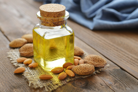 Almond oil in bottle on wooden backgroundの写真素材
