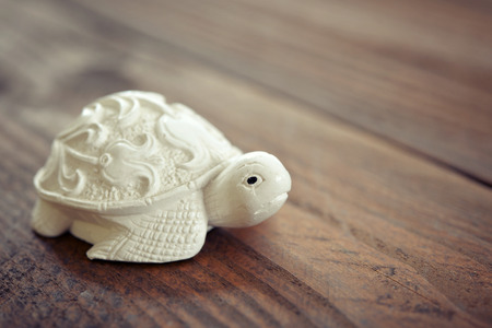 Ceramic figurine of turtle on wooden backgroundの写真素材