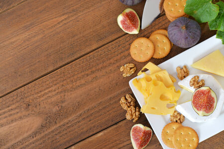 Different kinds of cheese with walnuts and fresh figs on wooden backgroundの写真素材